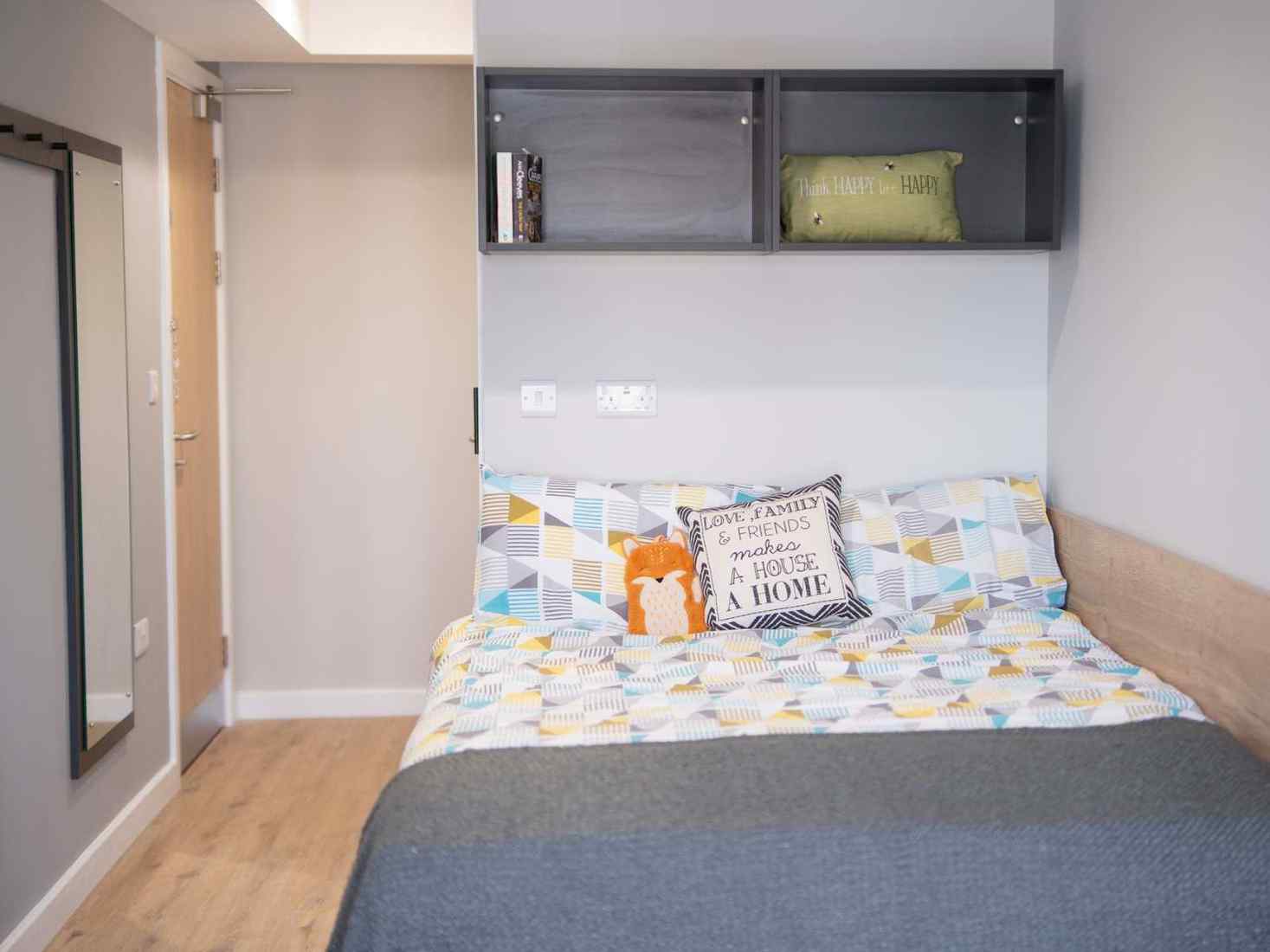 An image of a standard room in 79 Clarence Street accommodation, including single bed, desk and storage space 