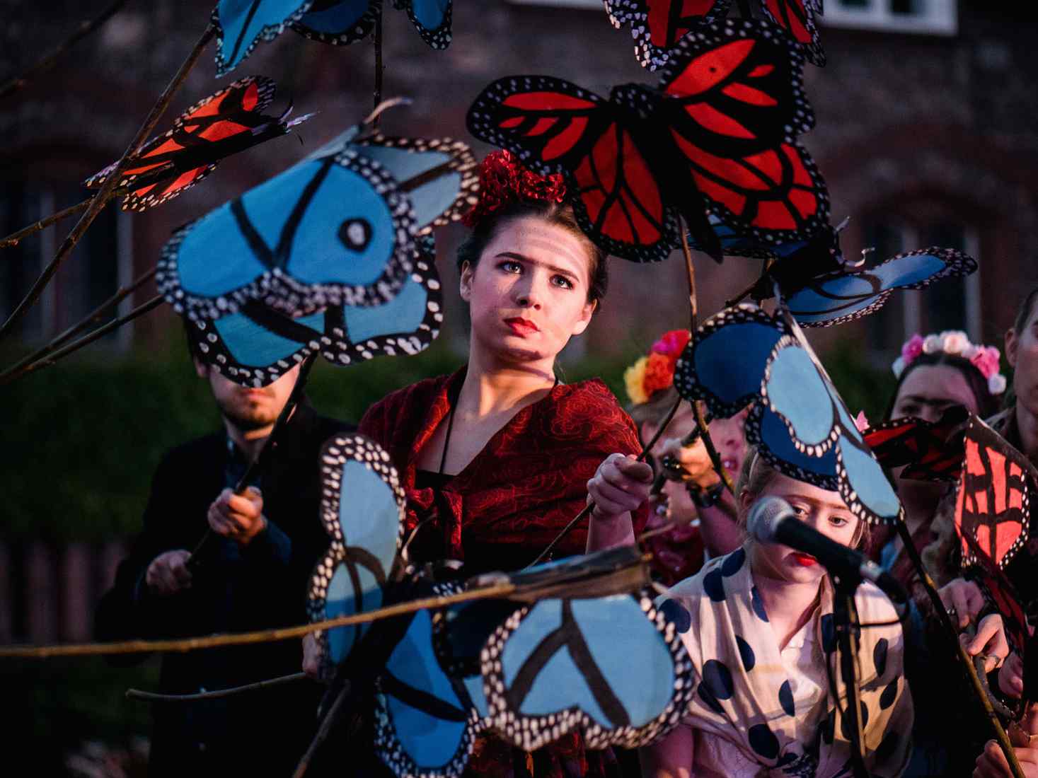Students performing outside with puppets 