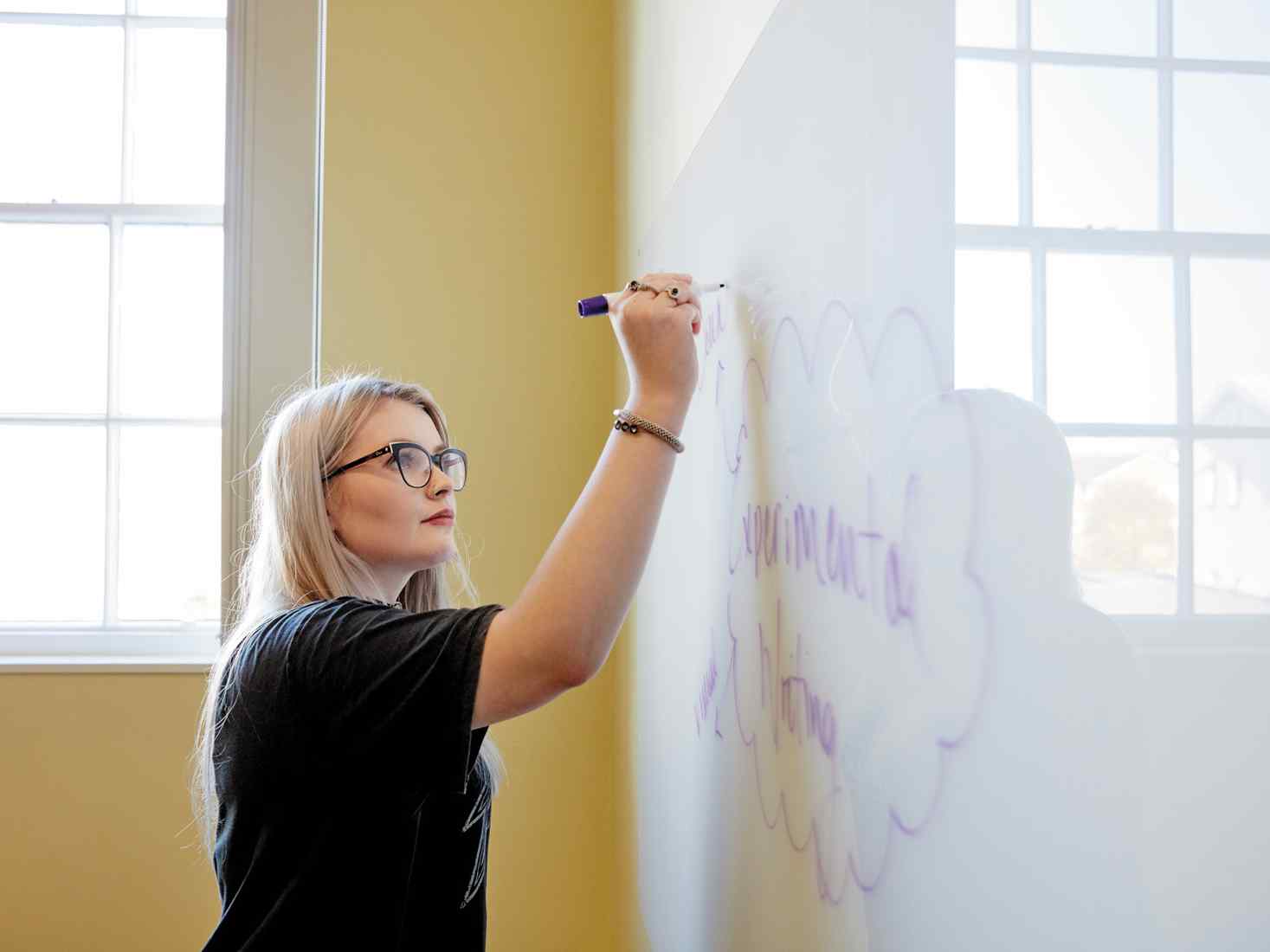 Student writing on whiteboard 