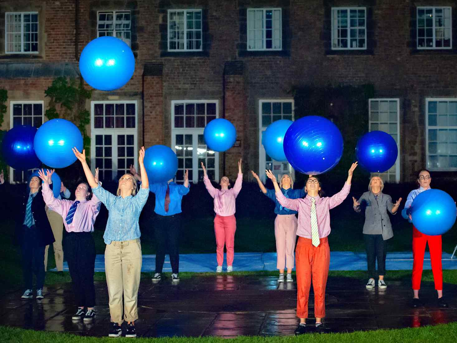 Students outside on campus throwing giant balls in the air 