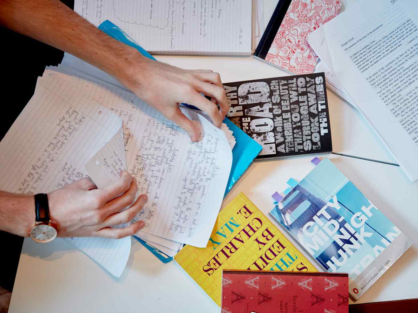 Overhead view of student with books and handwritten notes. 