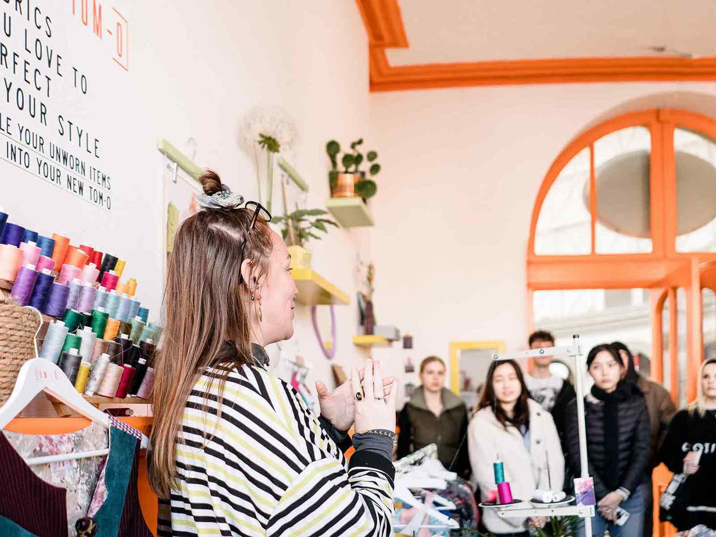 Fashion marketing lecturer talking to students on a field trip. 