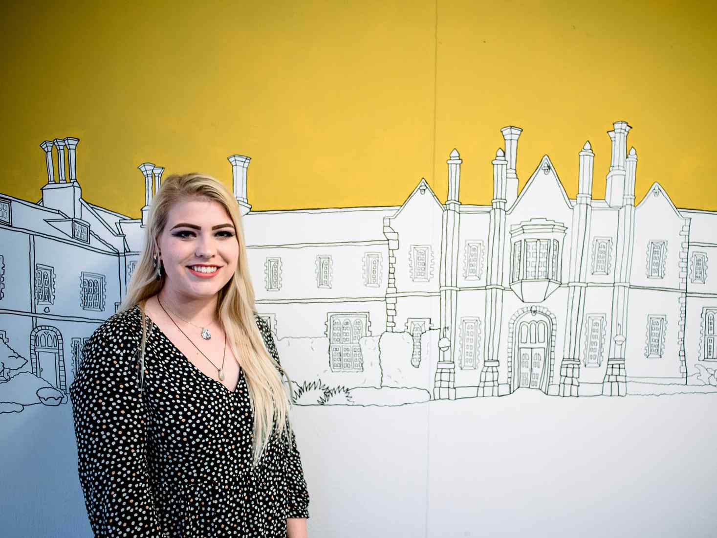 Student standing beside illustration work 