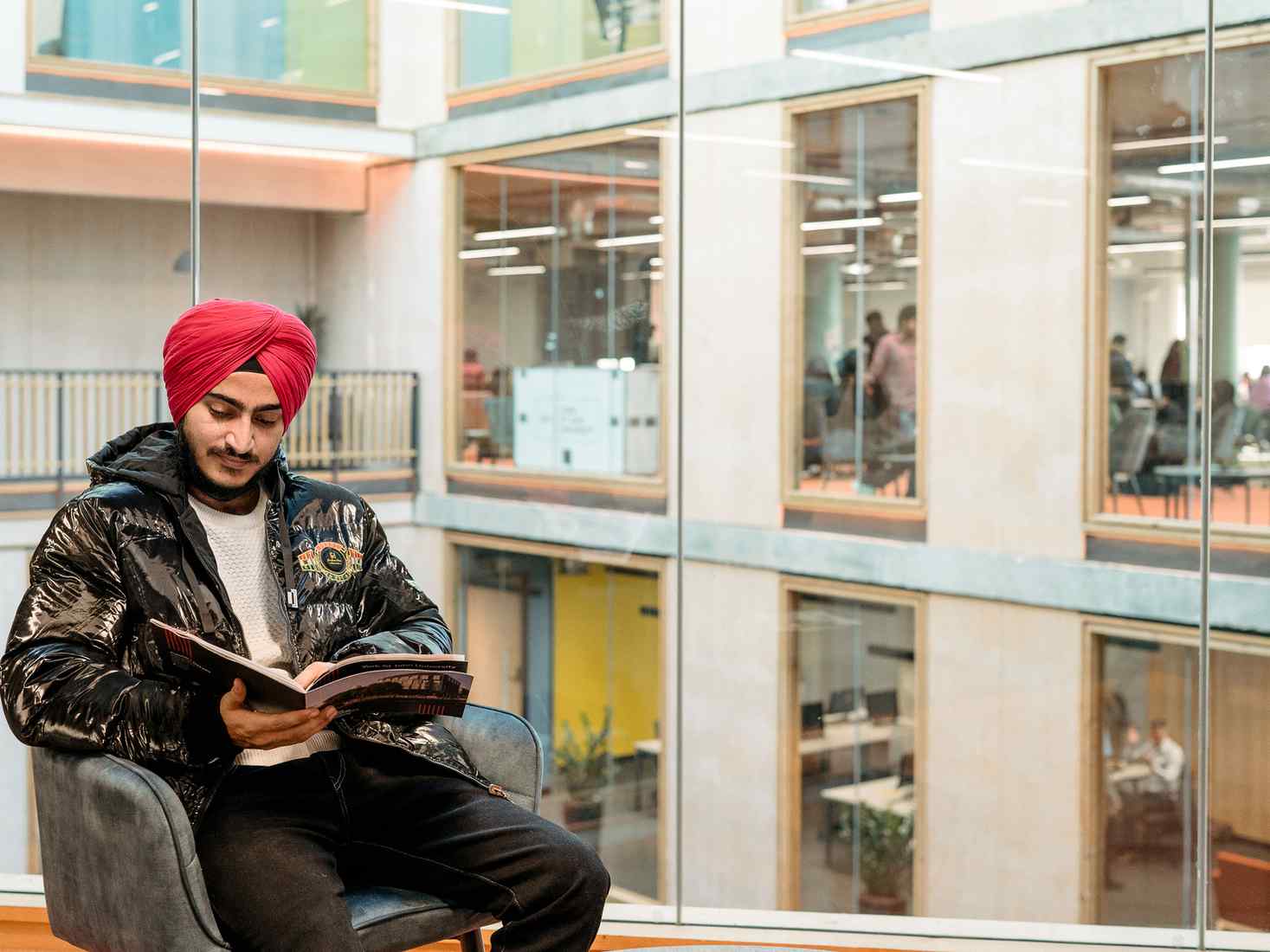 Student reading a book at London Campus. 