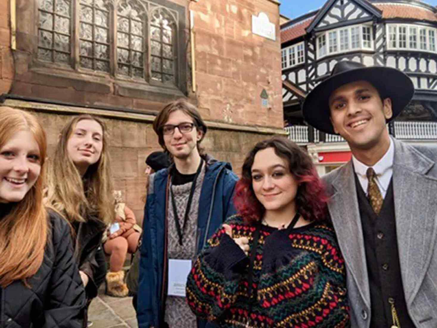 Students taking a selfie in front of historic buildings. 
