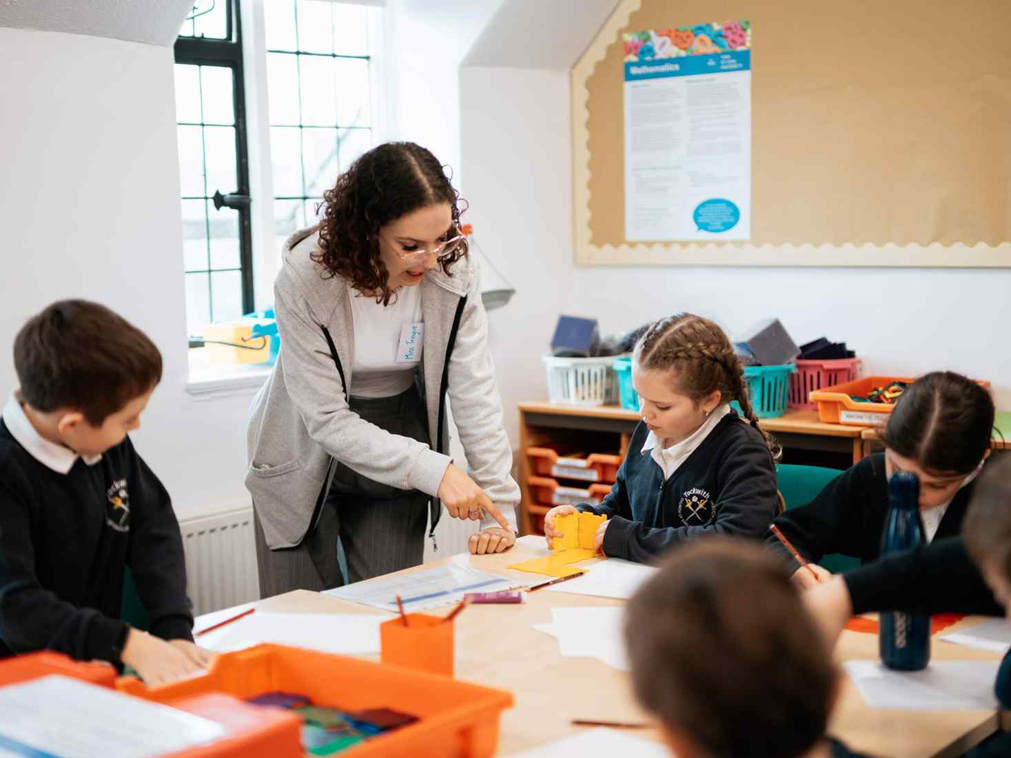 A student teacher working with children in class. 