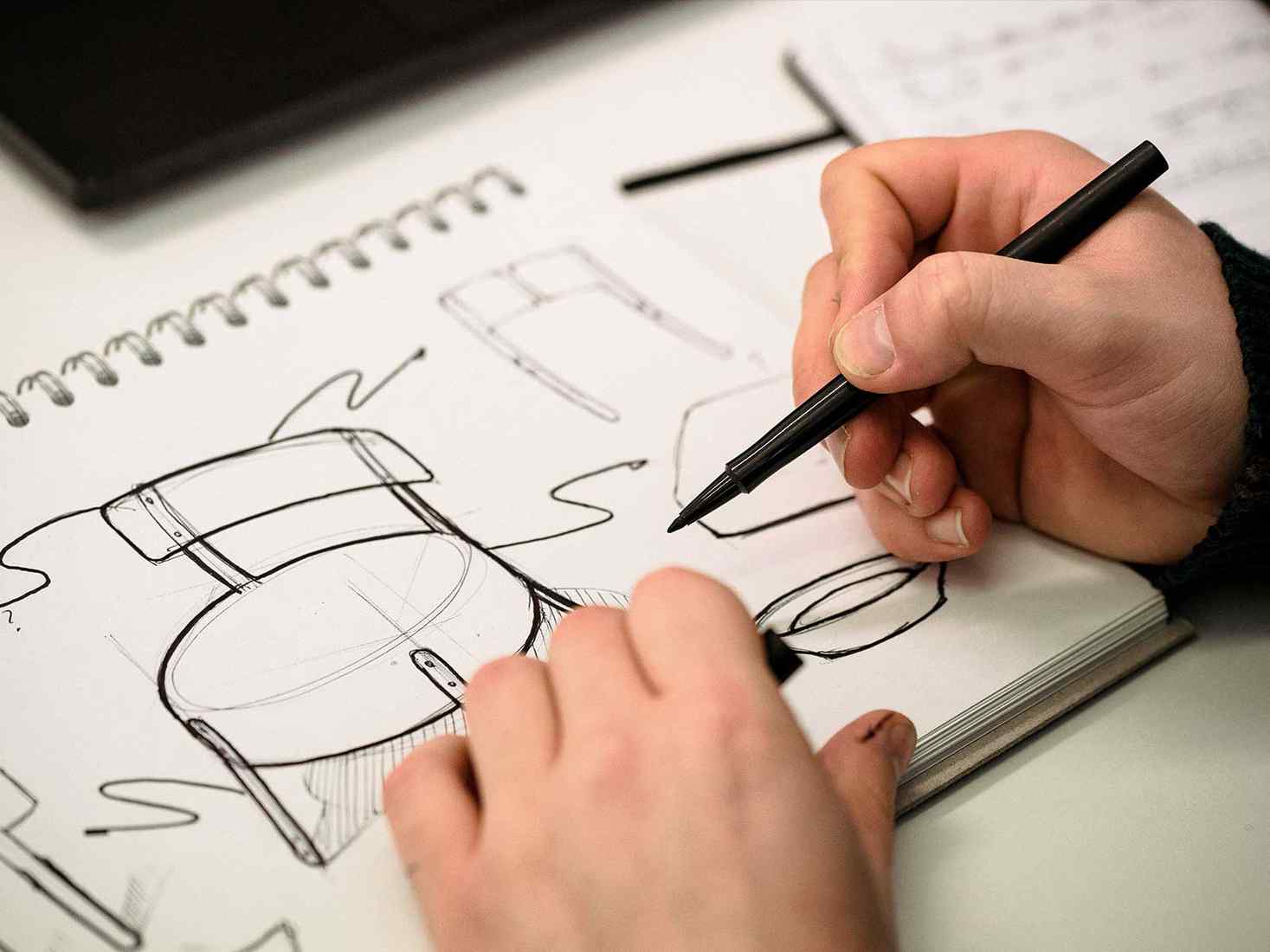 Close up of hands drawing product design sketches 