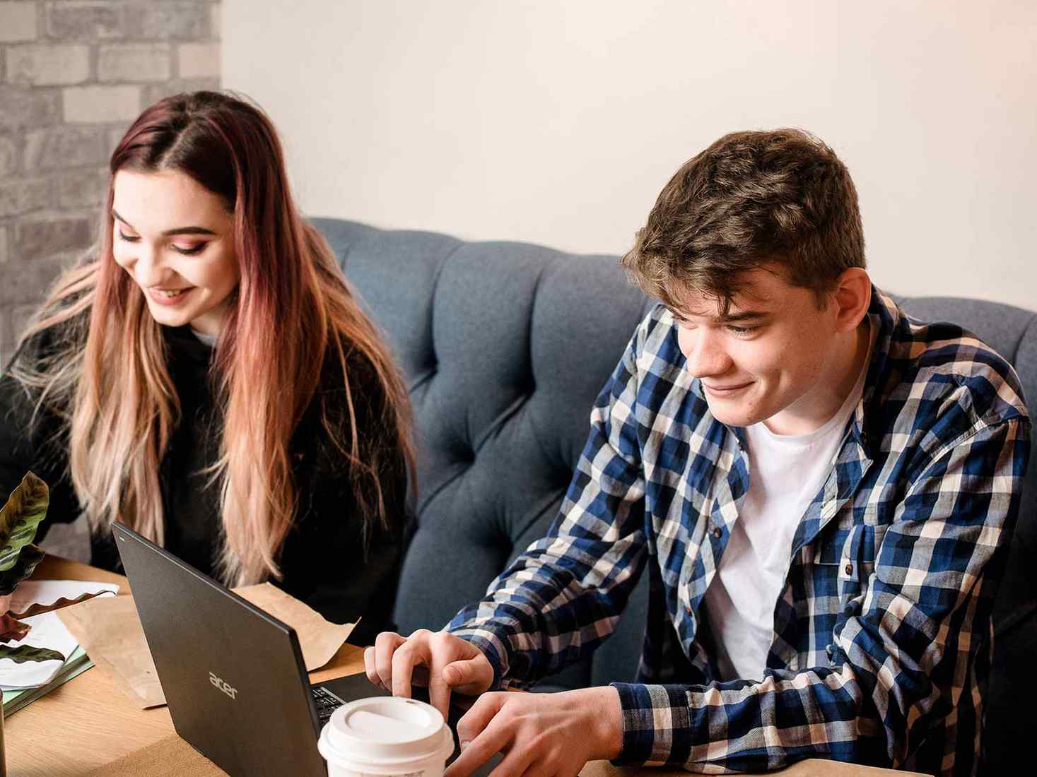 Two students in the SU. A laptop is on the table 