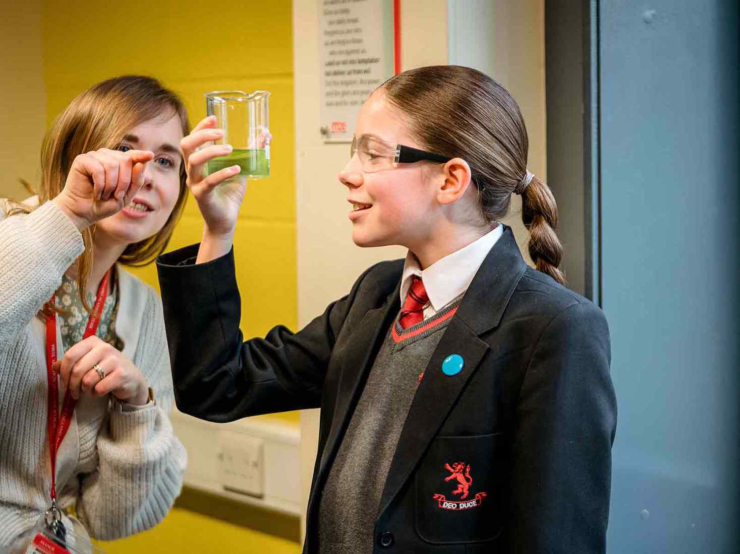 School student holding up science equipment 