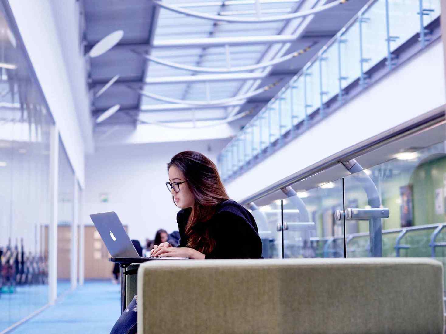 A student works on a laptop in the York St John library. 