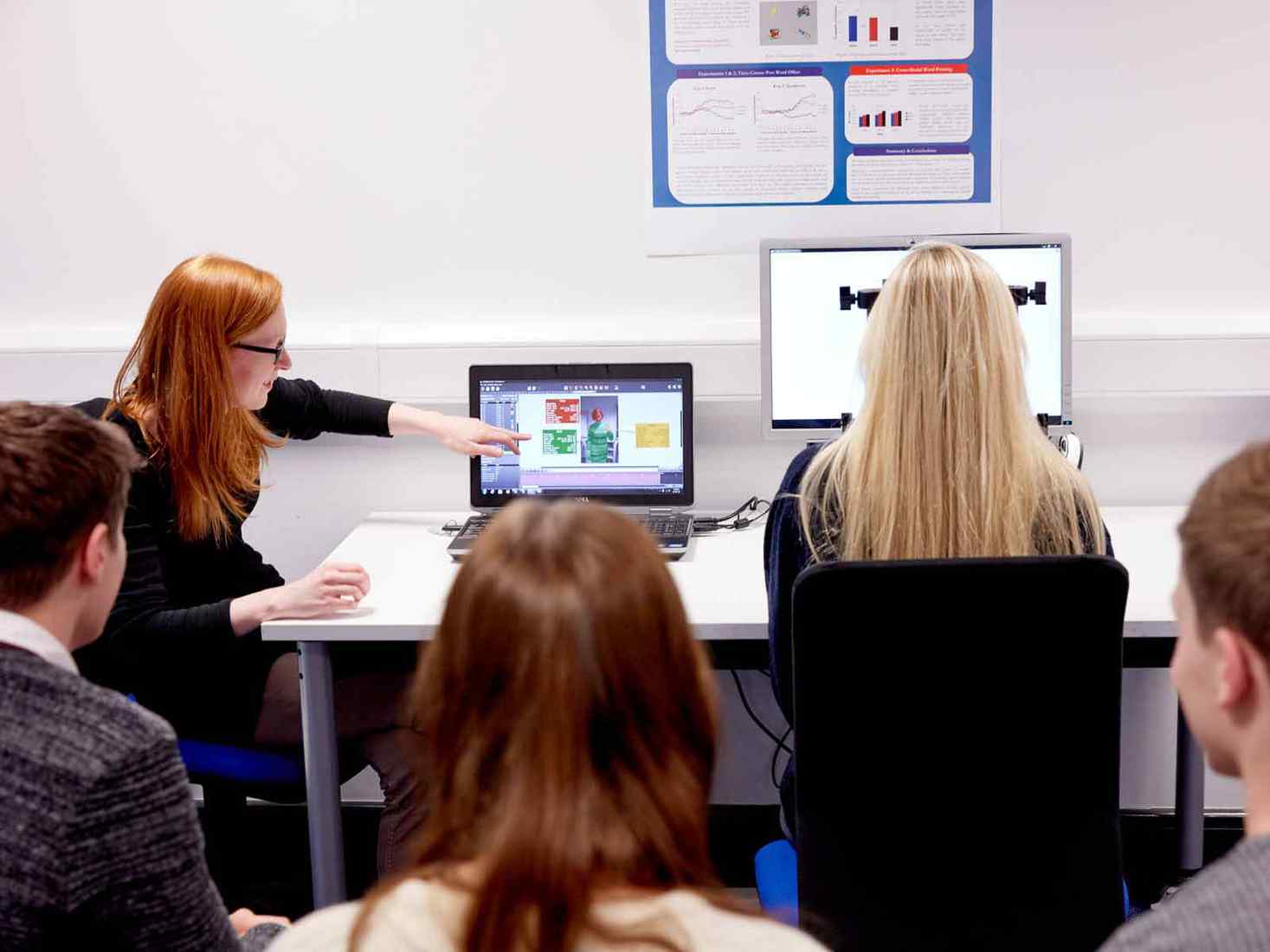 Students and a tutor working together at a computer. 