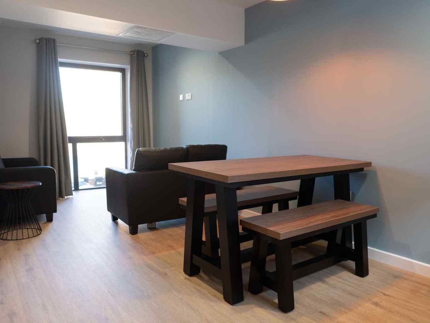 An image of a Kitchen in 49 Clarence Street accommodation, including a table, window, and cupboards 