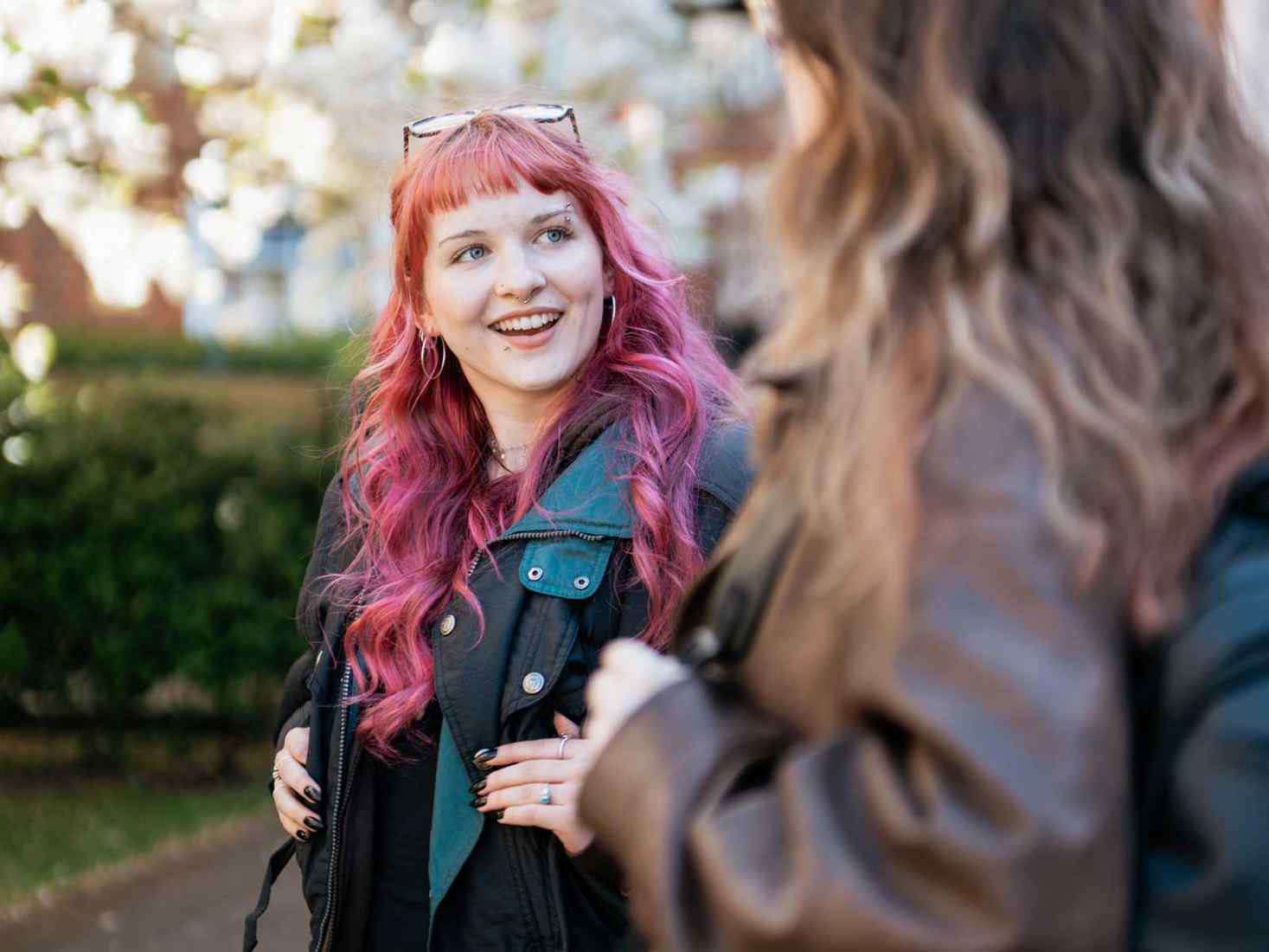 Two students talking to each other on campus. 