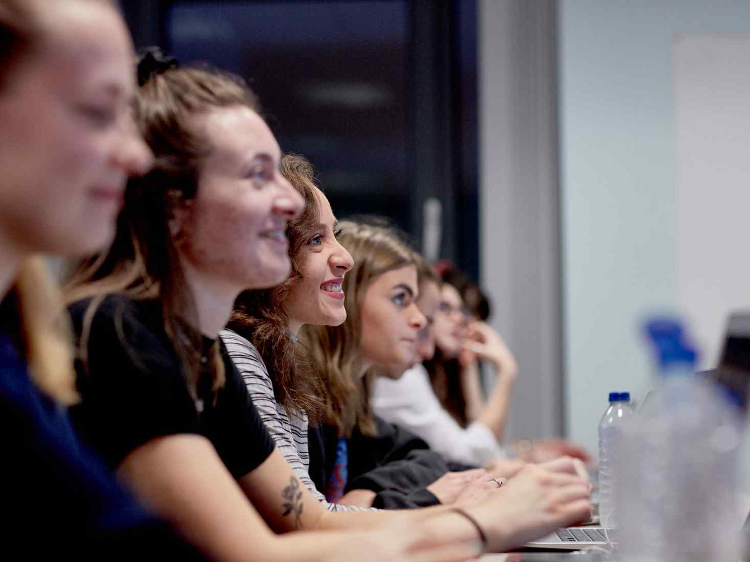 Students with laptops listening to a lecture. 