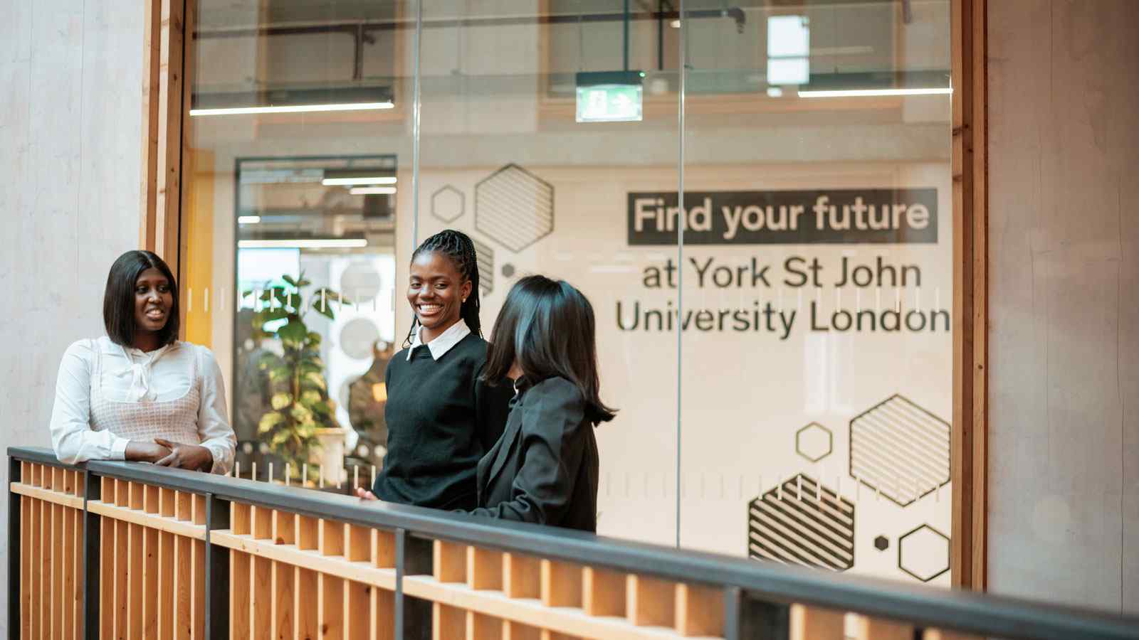 Small group of students besides railing at London campus 