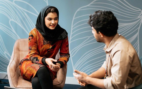 A student and staff member talking together. 