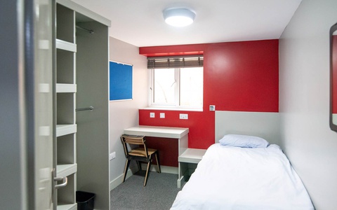 An image of a standard room in 49 Clarence Street accommodation, including single bed, desk and storage space 