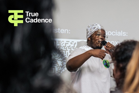 An individual singing with a microphone in front of audience 