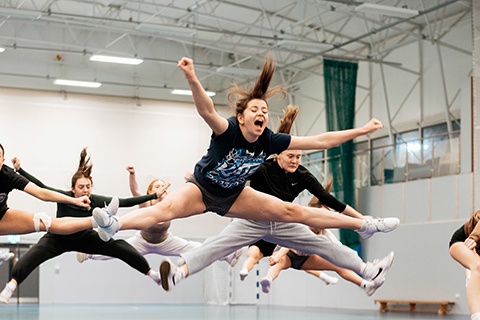 Cheerleading society in rehearsal at York St John, jumping in the air 