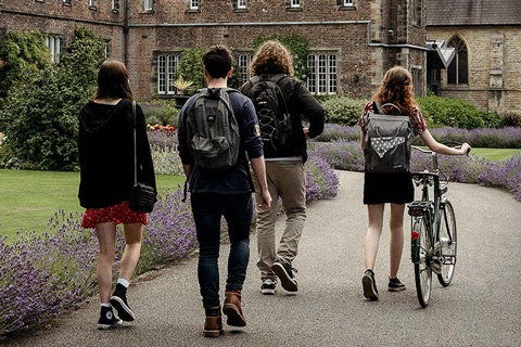 Four students walking towards the entrance of the Quad building on York St John University York Campus. 