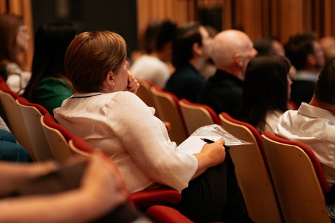 People sitting in the rows of the Creative Centre auditorium at York St John University campus. 