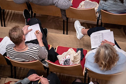Attendees at a conference taking notes 