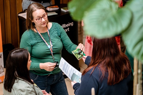 A member of staff speaking to a prospective student at an open day. 