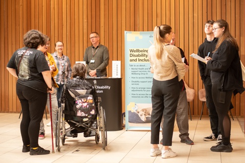 Attendees speaking to a support team at an Open Day. 
