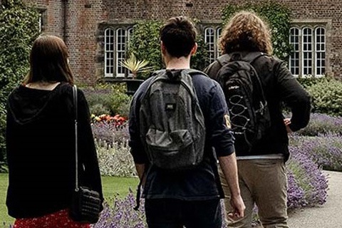 Three students walking towards the entrance of the Quad building on York St John University York Campus. 