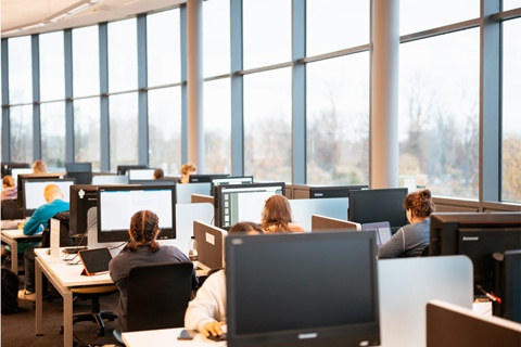 Students working at computers in the Fountains Library at York St John University York Campus. 