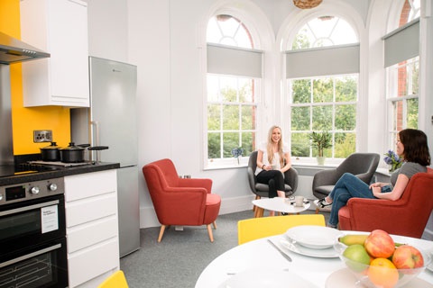 Two female students sat chatting in The Grange accommodation 