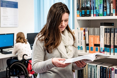 Student browsing Law section of Library 