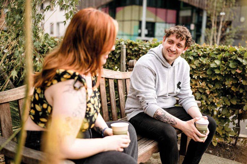 Two individuals talking together outside at York St John University's York Campus 