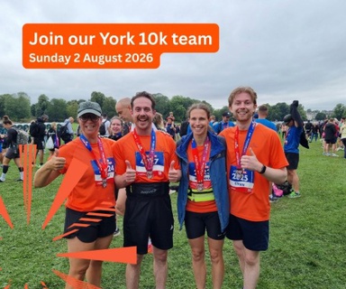Staff members in running gear wearing their medals and team t-shirts after completing the York 10K. 