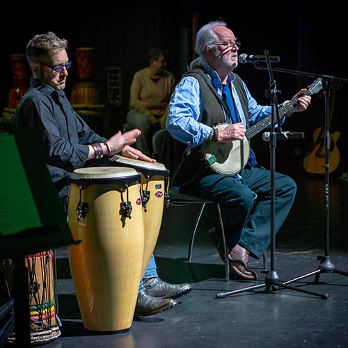 Two Converge students perform on drums and banjo 