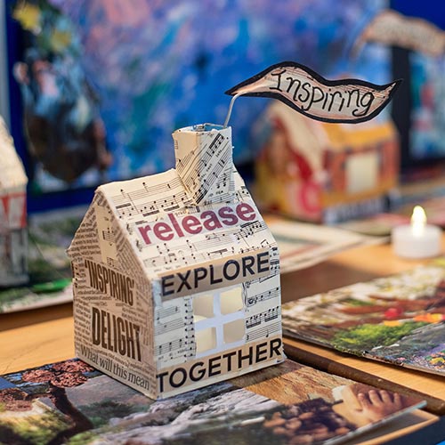 Converge art model house covered in text cut out from magazines 