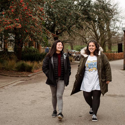 Two students walking on campus. 