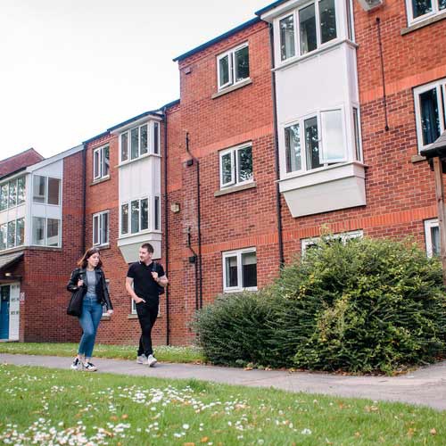 Two students walking outside The Grange accommodation site. 