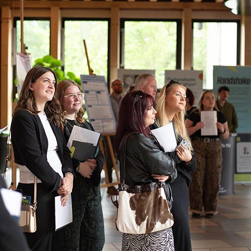 Students stood next to research posters at the York School of Business Research Symposium 