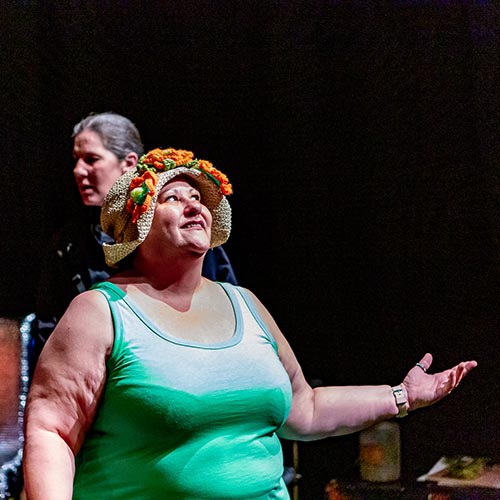 Converge student performing on stage wearing a sun hat 