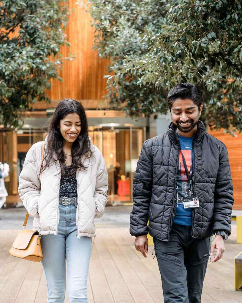 Student and staff member walking outside London Campus 